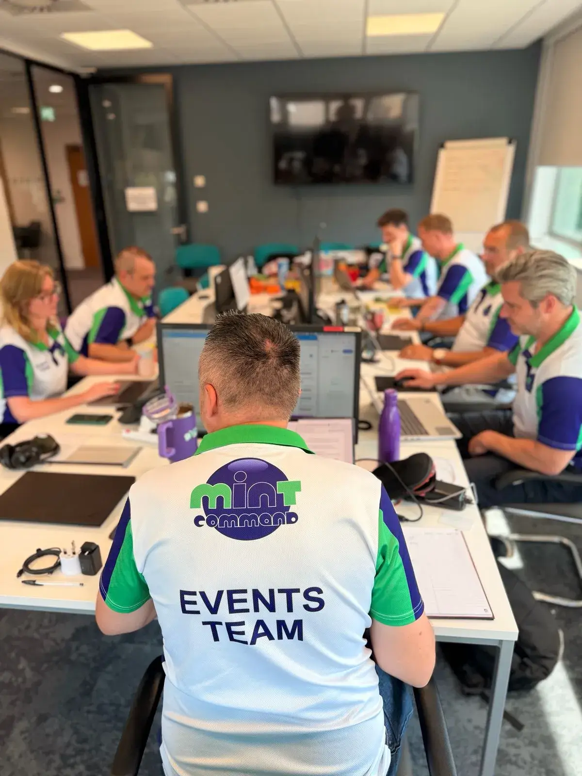 Mint Command events team working in a control room environment with branded Mint workwear